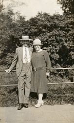 Mann og kvinne med hatt stående ved et gjerde
