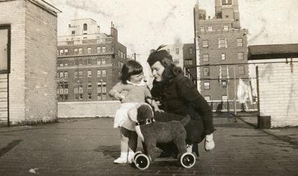 Kristine Gullestad og en liten pike med en lekehund på hjul