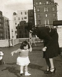 Kristine Gullestad og en liten pike, i forgrunnen en lekehund på hjul