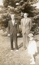  To menn og en liten gutt i en hage.